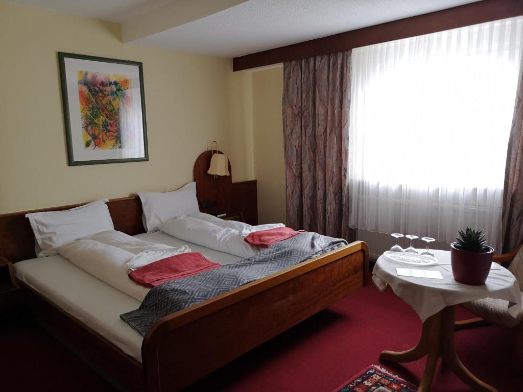 Gadernheim泽尔巴查胡福宾馆的一间卧室设有一张床、一个窗口和一张桌子