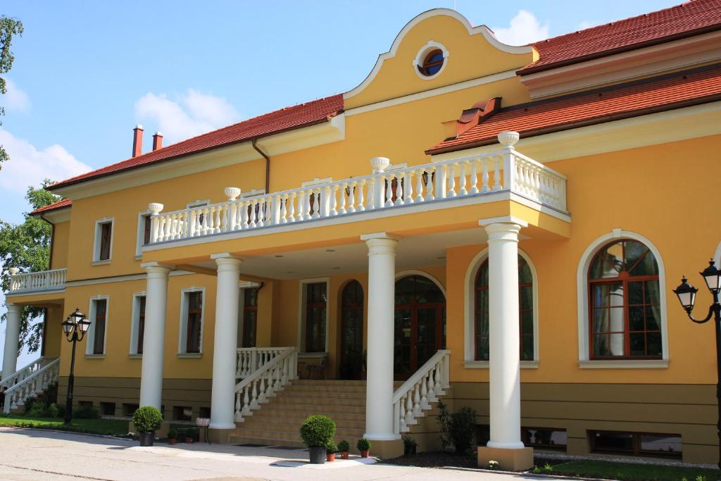 大梅杰尔普劳特库瑞亚酒店的黄色房屋 - 带阳台和楼梯