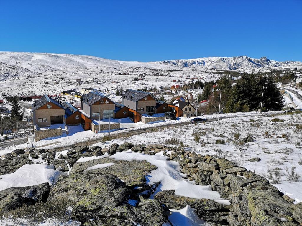 佩尼亚什达绍迪Estrela da Serra - Alojamento Local的雪中的一个村庄,有房子和岩石