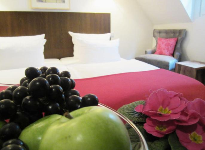 吕德斯海姆林德沃特酒店的一间卧室配有一张床和一碗水果