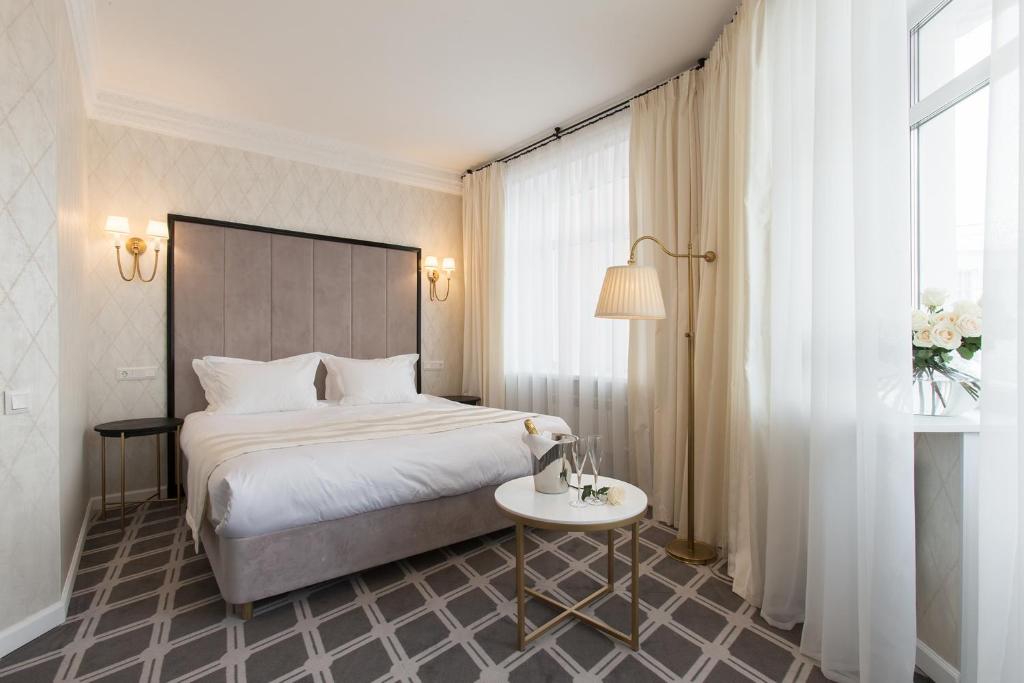 巴尔瑙尔Altay Hotel的酒店客房配有一张床铺和一张桌子。