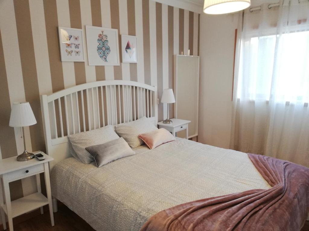 里奥廷托Apartamento da Giesta的一间卧室配有一张带两张桌子和一扇窗户的床。