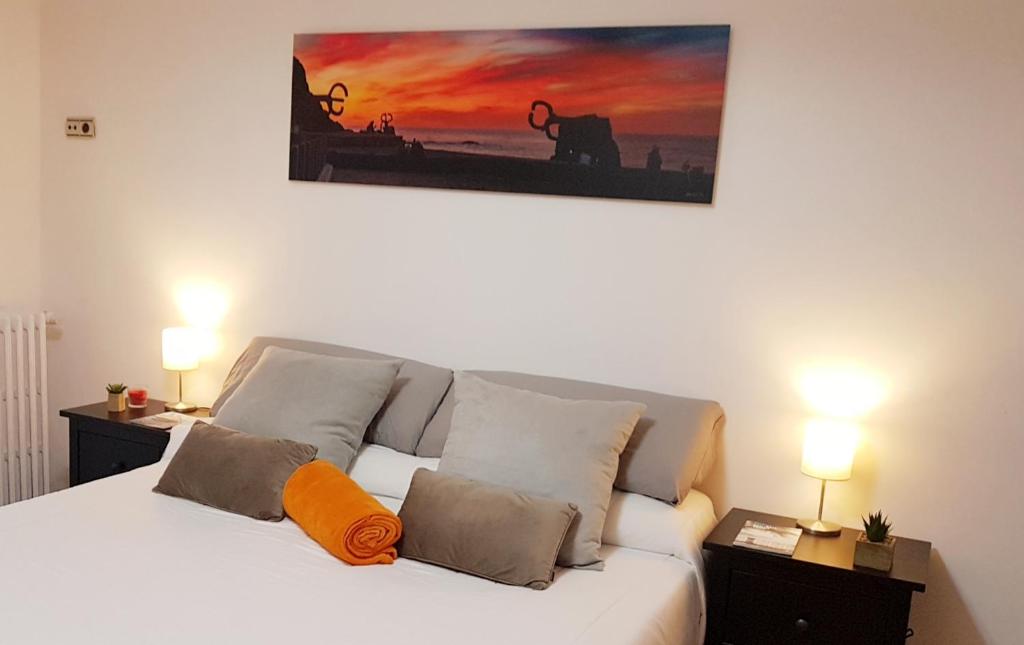 圣塞瓦斯蒂安URBIETA CENTRO的卧室配有白色床和橙色枕头