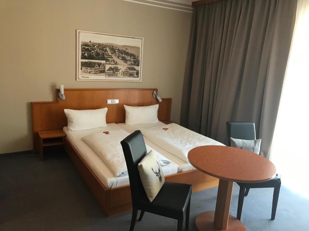 魏森霍恩纽梅尔斯赫斯乡村酒店的酒店客房带一张床、一张桌子和椅子