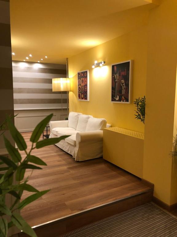 拉文纳Apartment Hotel Marchesini的客厅配有白色沙发和植物