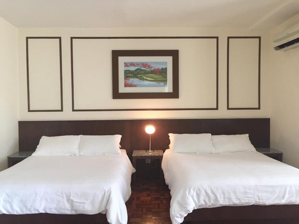 马六甲D savoy @ Famosa by MR的配有白色床单的酒店客房内的两张床