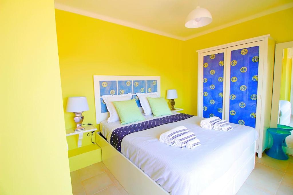 加凡哈达瓦古耶拉RiaMar - Praia da Vagueira的一间卧室设有两张黄色和蓝色墙壁的床