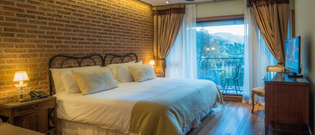 圣马丁德洛斯Paraíso Casa de Montaña的一间卧室设有一张床和砖墙