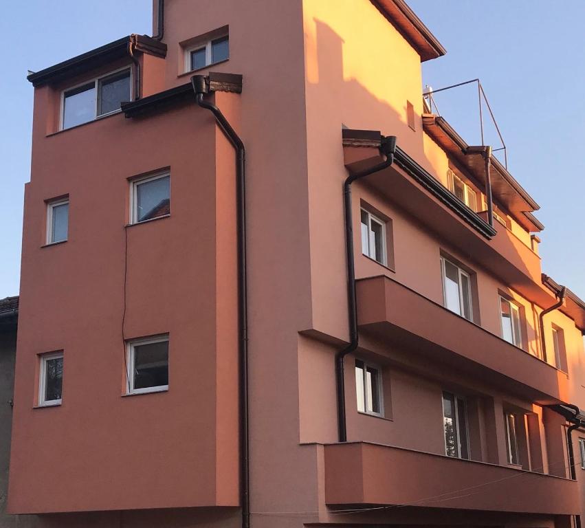 布拉戈耶夫格勒Central House的一座高大的橙色建筑,侧面设有阳台