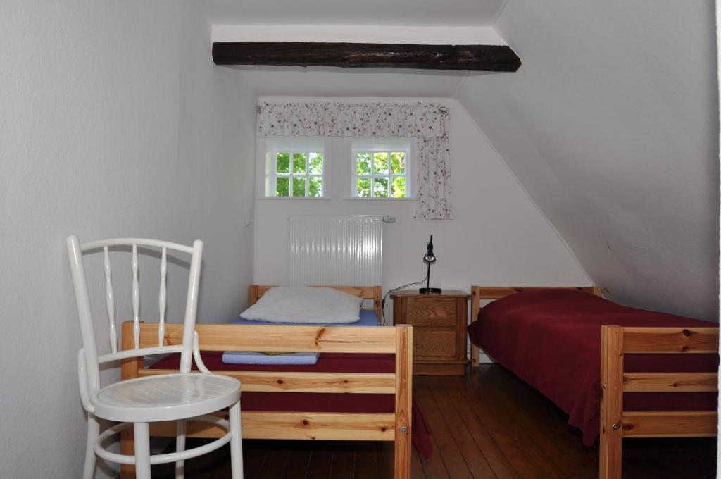 KirchlintelnFerienhäuser Armsen的卧室配有床、椅子和窗户。