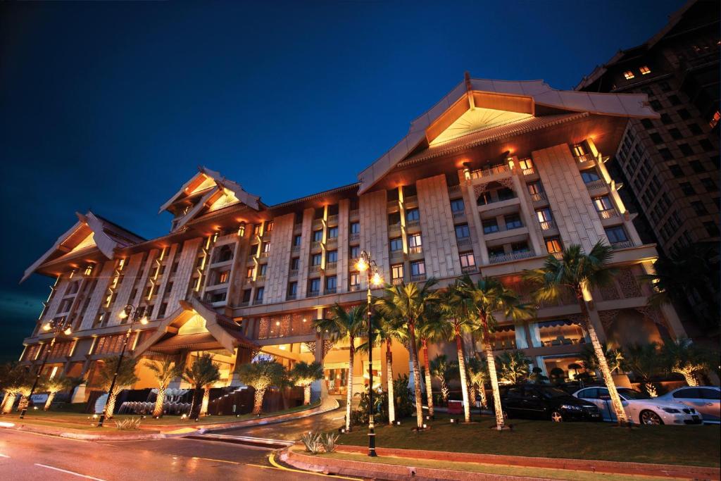 吉隆坡吉隆坡皇家朱兰酒店的一条街道前方有棕榈树的大建筑