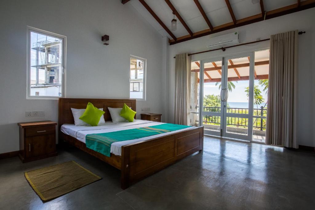 帕西库达Blue Sands Beach Resort的一间卧室配有一张带绿色枕头的床