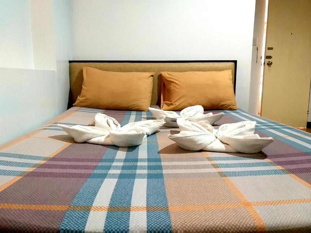 马尼拉Sola Eleganza Apartelle的床上铺有白色枕头的床