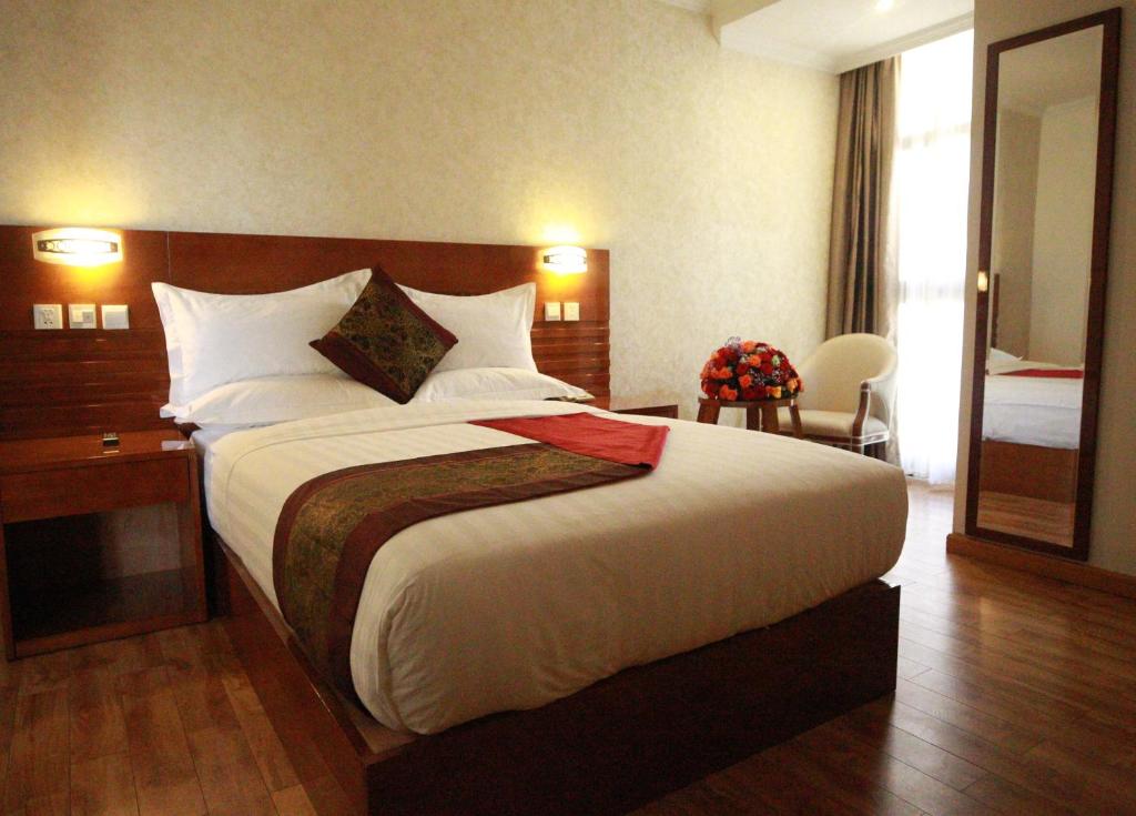 亚的斯亚贝巴Marcen Addis Hotel的配有一张大床和镜子的酒店客房