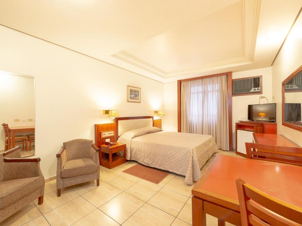 圣保罗雷亚尔卡斯蒂拉酒店的酒店客房,配有一张床、一张桌子和椅子