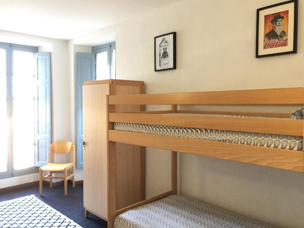 Olivese杰特皮特雷木屋酒店的配有双层床和椅子的房间