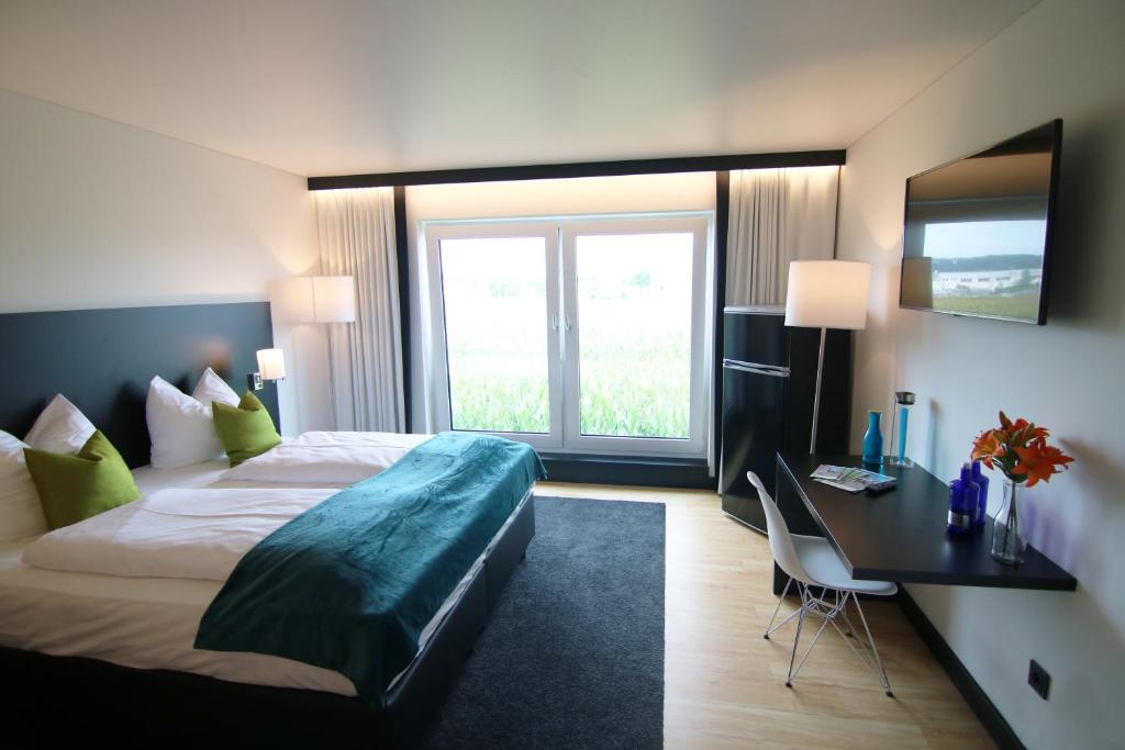 MeitingenME Hotel by WMM Hotels的酒店客房设有一张床和一张带窗户的书桌