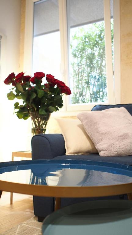 波尔多Esprit Bordelais的客厅配有蓝色的沙发和玻璃桌