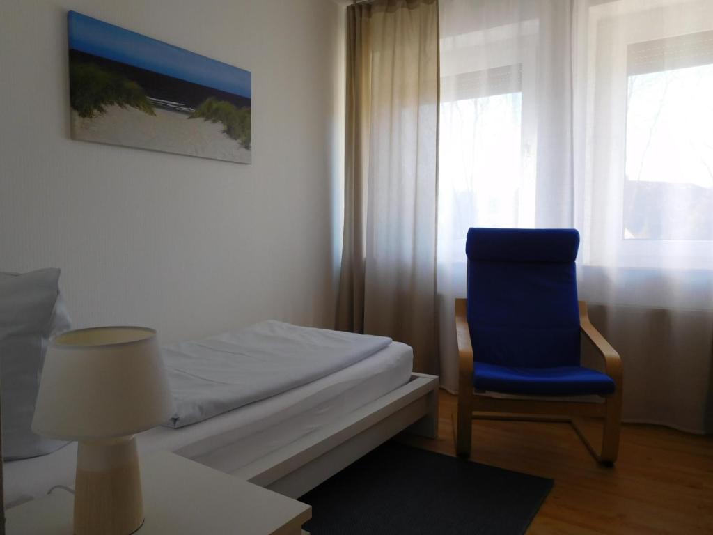 布尔格韦德尔Arkadia Hotel的一间卧室配有一张床和一张蓝色椅子