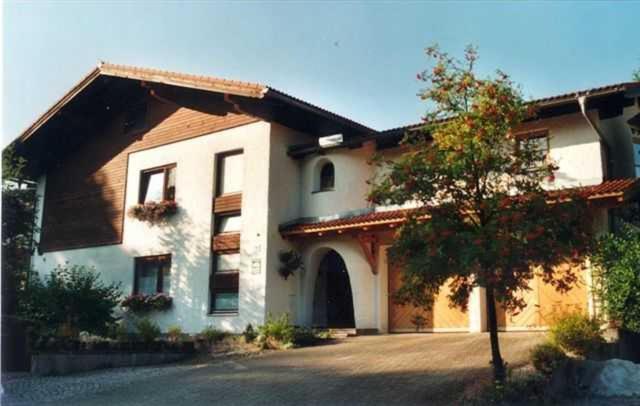 萨尔茨堡附近霍夫Haus Helga的前面有一棵树的大白色房子