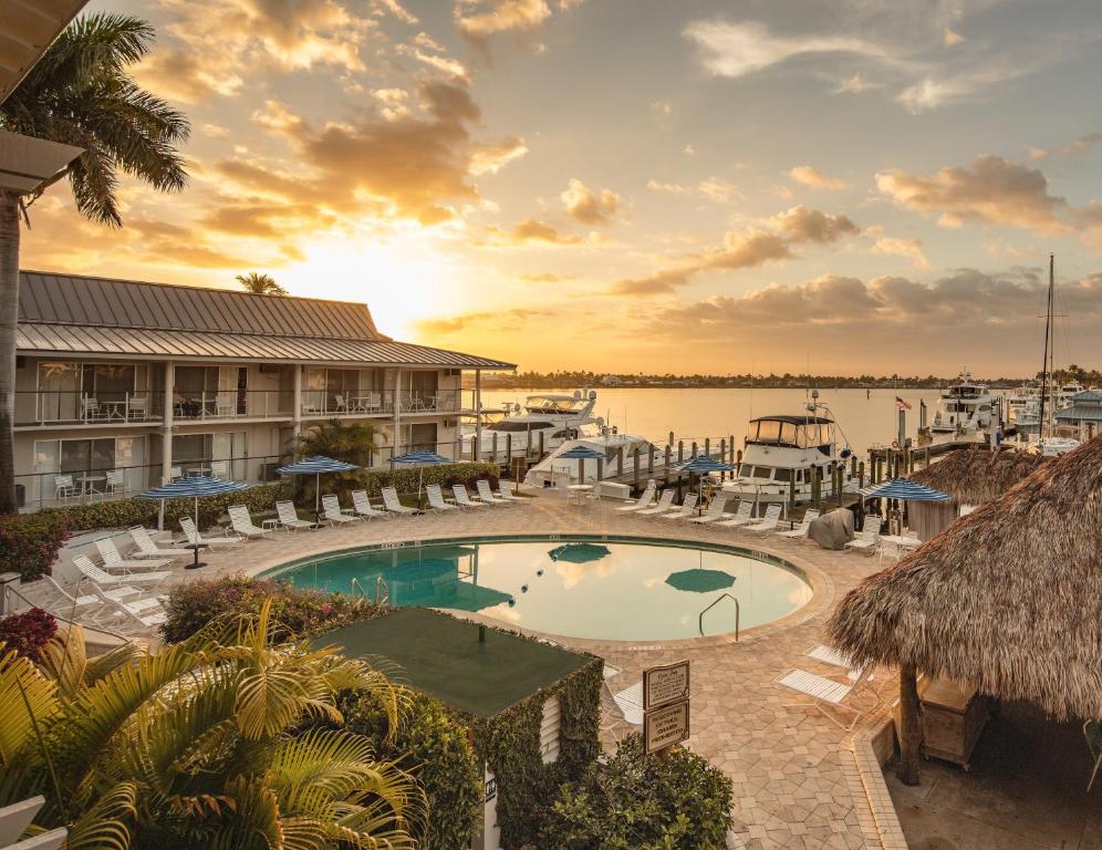 那不勒斯那不勒斯湾海湾酒店的日落时分带游泳池和码头的度假村