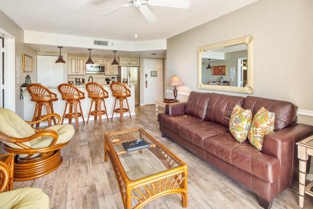 基韦斯特Sunrise Suites Tahiti Suite #104的客厅配有棕色真皮沙发和椅子