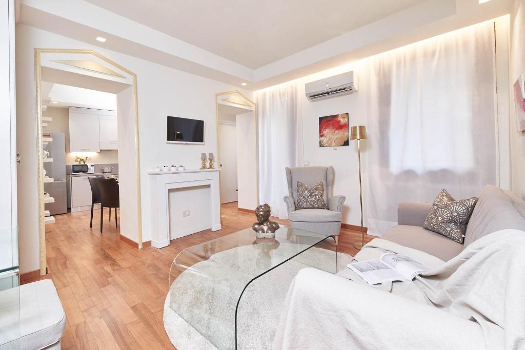 维琴察AppartamentoPalladio140的客厅配有白色沙发和玻璃桌