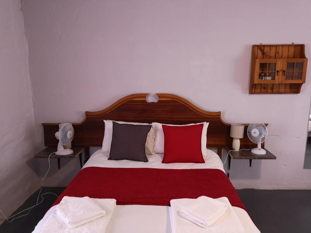 博福特西Kalamata的一间卧室配有一张带红色和灰色枕头的床
