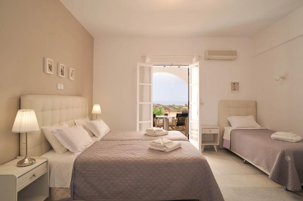 纳克索斯岛卡斯特拉基斯卡拉公寓 的一间白色卧室,配有两张床和窗户