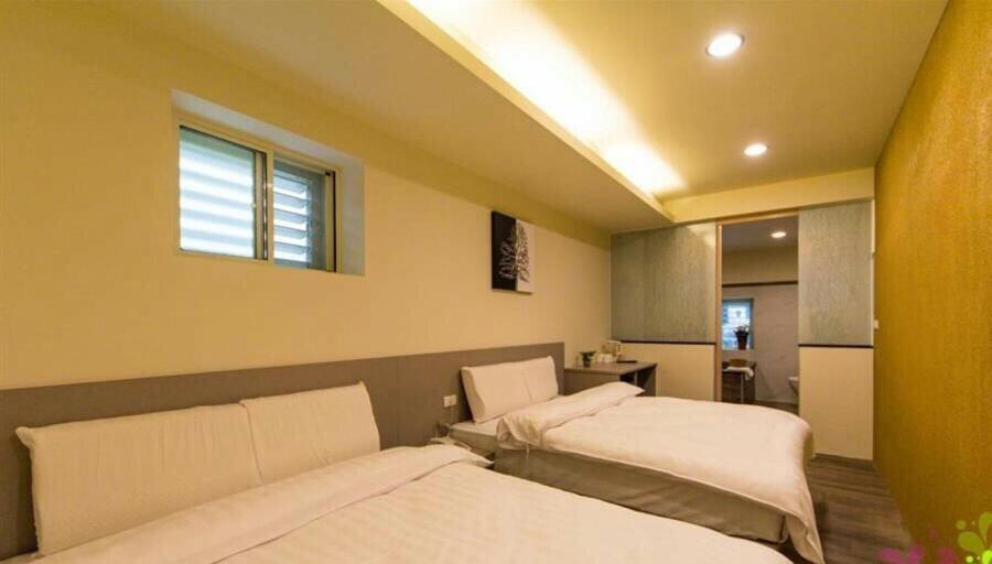 礁溪YY Elleys Home的一间卧室设有两张床和窗户。