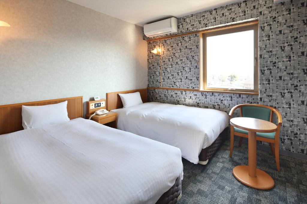 菊池市Green Rich Hotel Aso Kumamoto Airport (Artificial hot spring Futamata Yunohana)的酒店客房设有两张床和窗户。