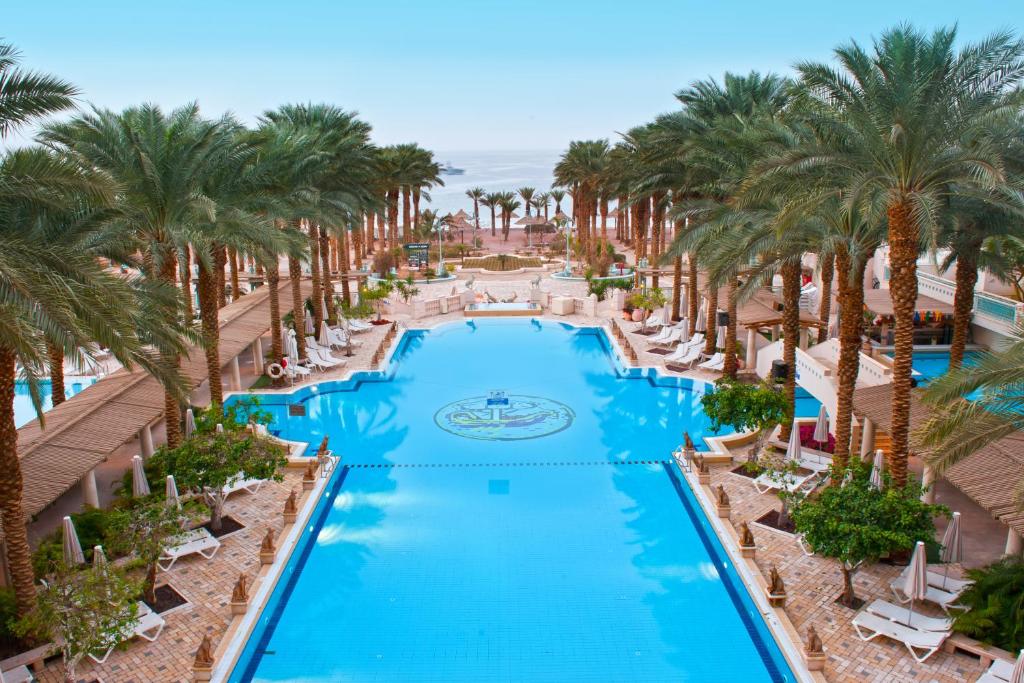 埃拉特Herods Palace Hotels & Spa Eilat a Premium collection by Fattal Hotels的棕榈树度假村泳池的空中景致