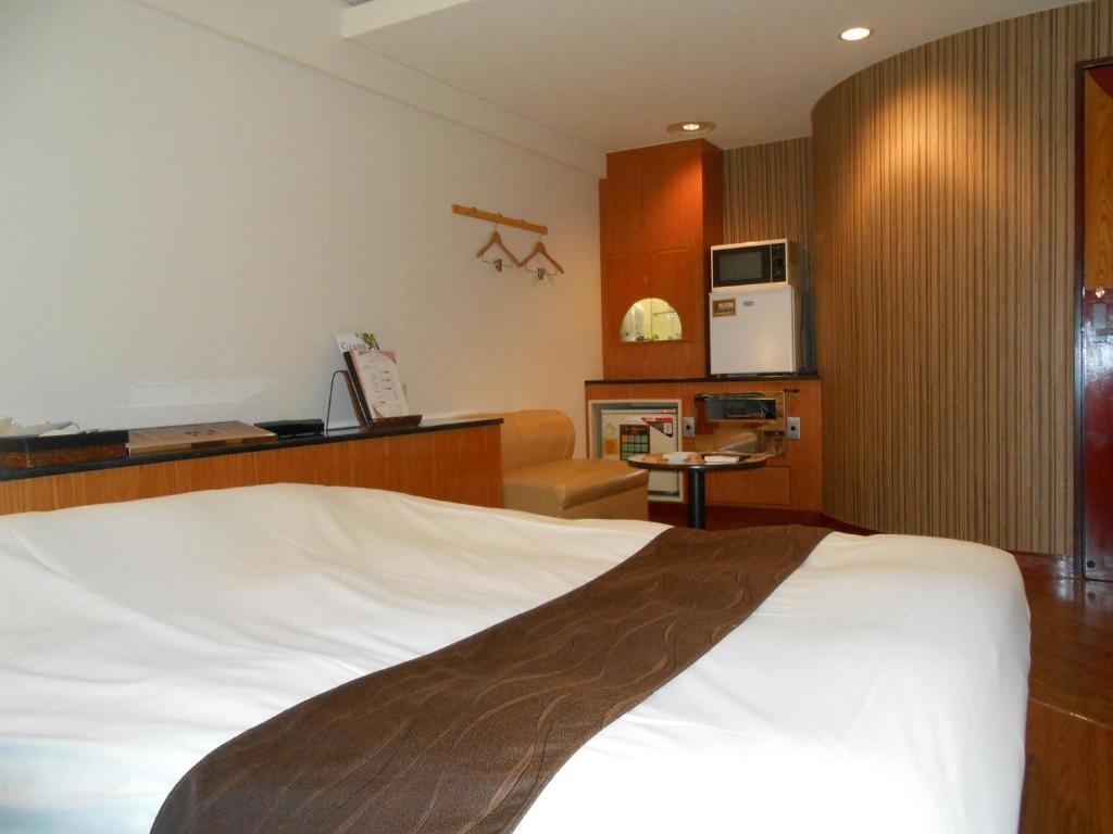 御殿场市Hotel Lumiere Gotenba (Adult Only)的酒店客房带一张床和一个厨房