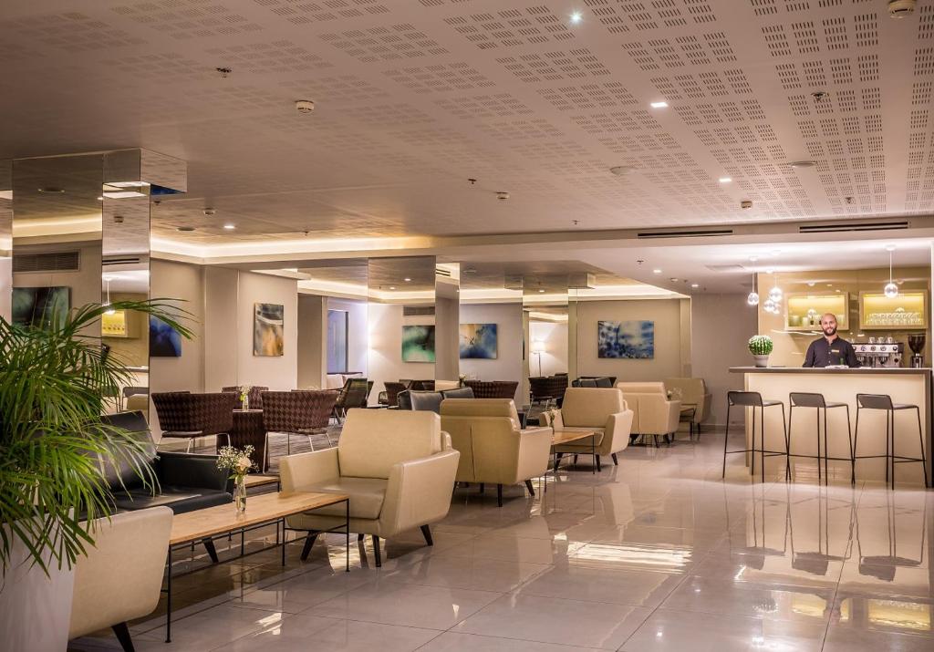 埃拉特Hotel Astral Nirvana Club- Half Board的大堂设有配备椅子的等候室和酒吧
