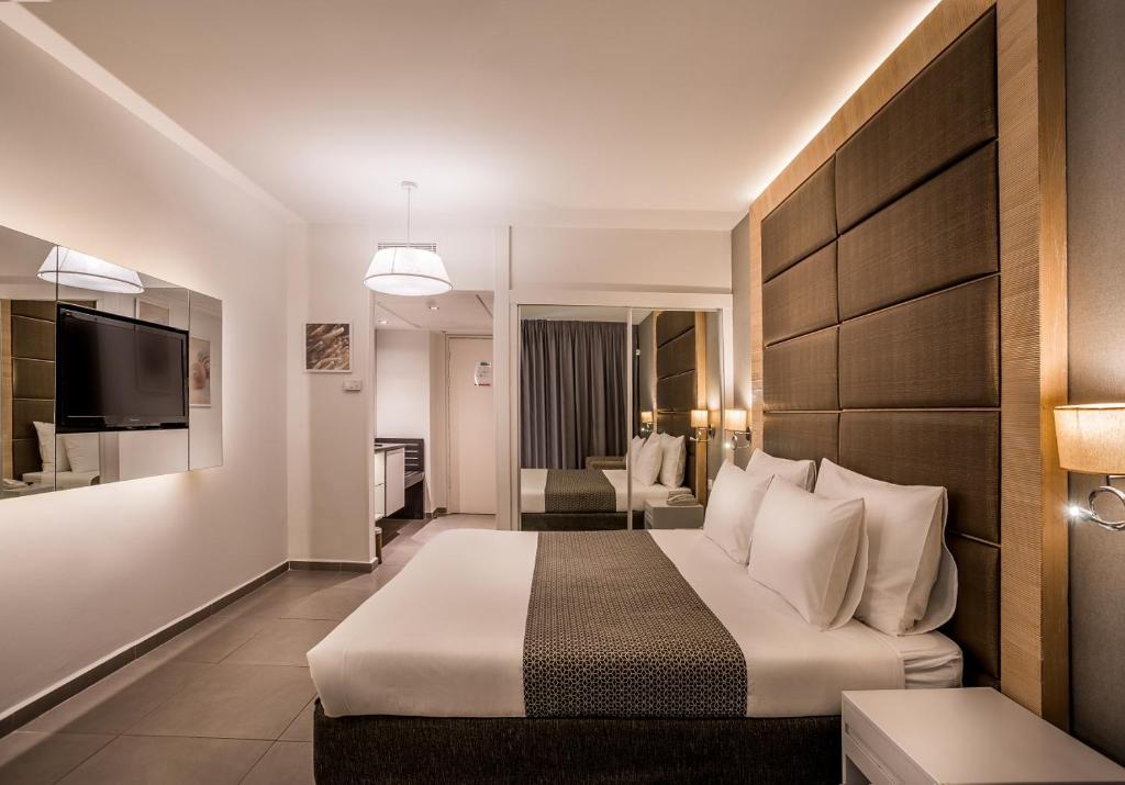 埃拉特Hotel Astral Nirvana Club- Half Board的一间带床和客厅的酒店房间