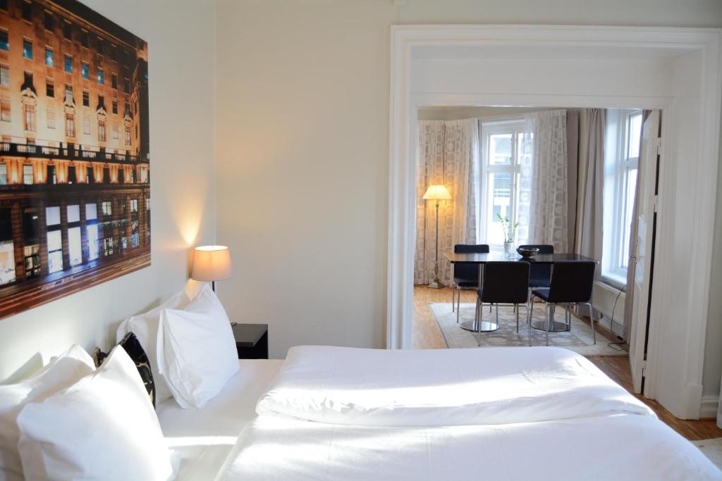 哥德堡DA Hotel Apartments的一间带白色床的卧室和一间用餐室