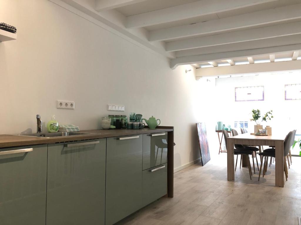 多德雷赫特No6a Luxe design appartement in historisch hart Dordrecht ALLES dichtbij!的一间带木桌的厨房和一间餐厅
