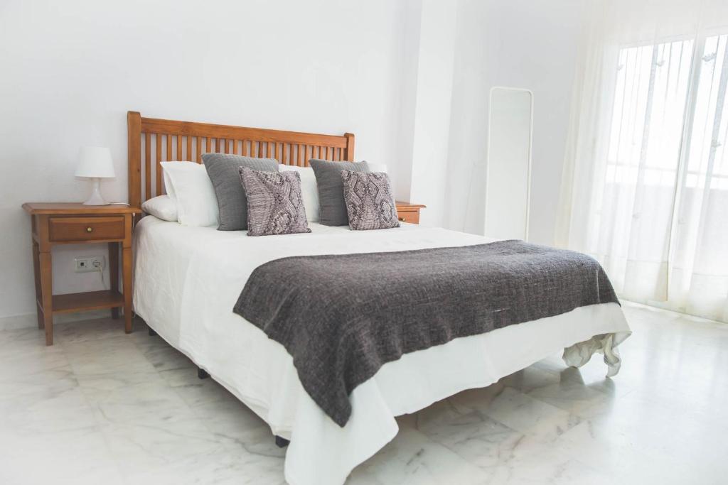 马贝拉Apartamento Las Chapas - bonito y tranquilo的白色卧室配有一张带枕头的大白色床