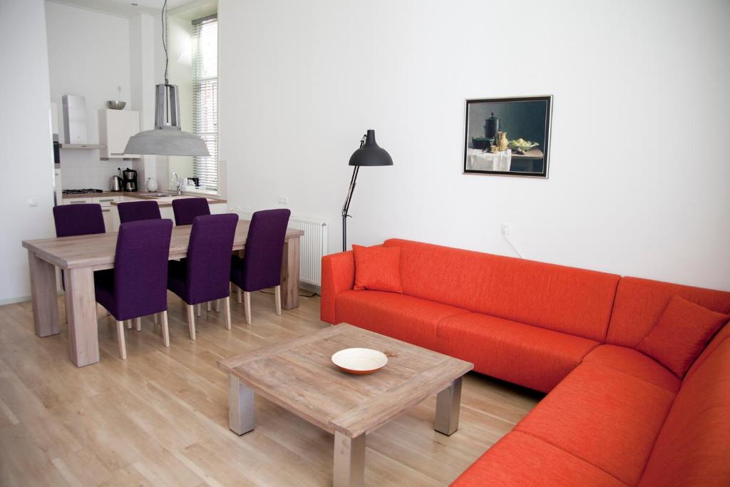 格罗宁根Gelkingehof Aparthotel的客厅配有红色的沙发和桌子