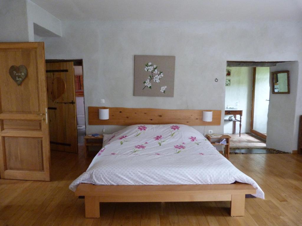 圣安德烈-德瓦尔博涅Cocon des Cévennes - Pierre de Lune的一间卧室配有一张带木制床头板的床