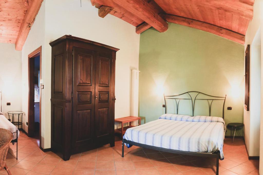 福萨诺Agriturismo Fiori di Zucca的一间卧室配有一张床和一个木制橱柜