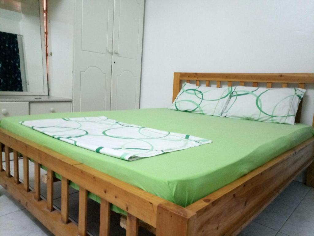 达累斯萨拉姆Apartment in Dar Homestay的一张木床,上面有绿毯