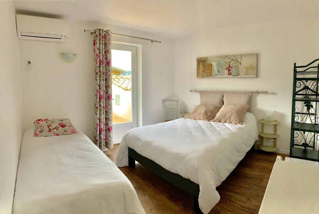 圣伊波利特迪福尔Logis Auberge Cigaloise的一间卧室设有两张床和窗户。