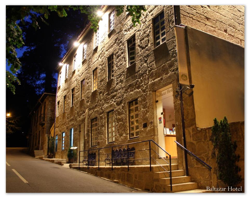 吉尔斯巴尔塔扎尔酒店的街上的砖砌建筑,晚上有楼梯