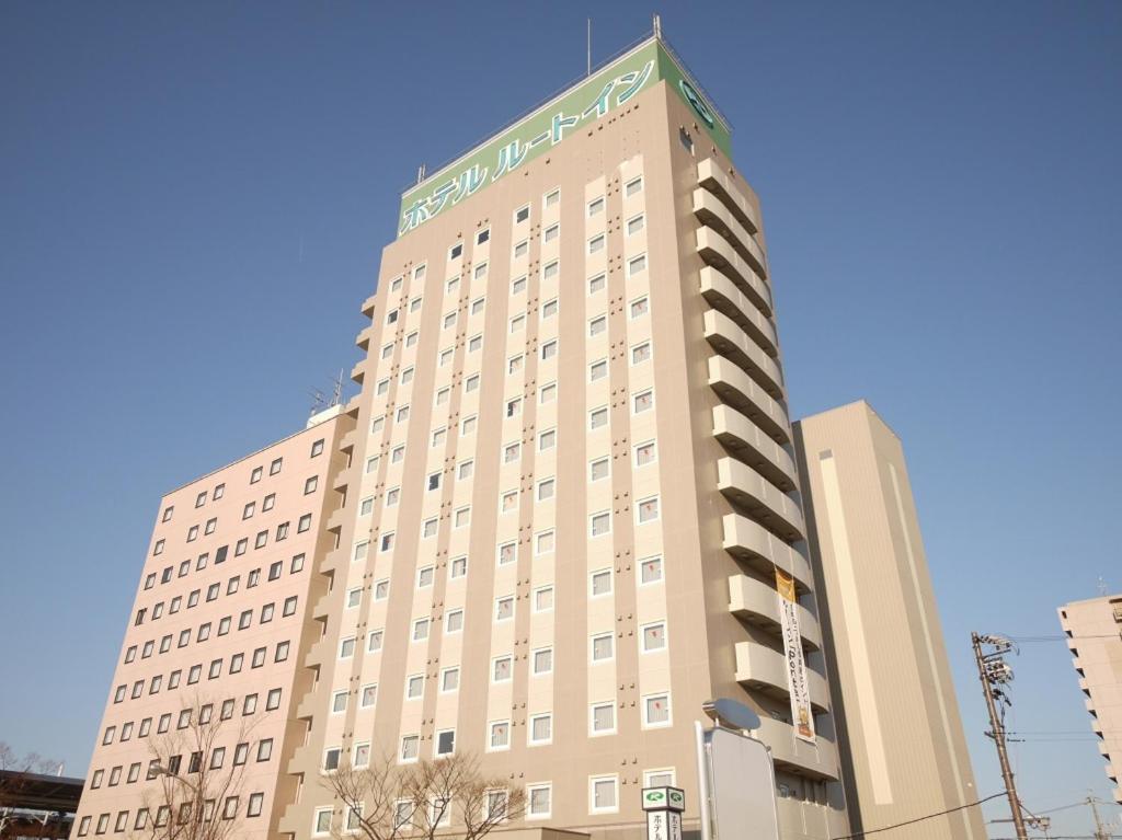 端岛鲁特酒店-吉夫哈斯玛艾科梅旅馆的一座高大的棕褐色建筑,上面有绿色的标志
