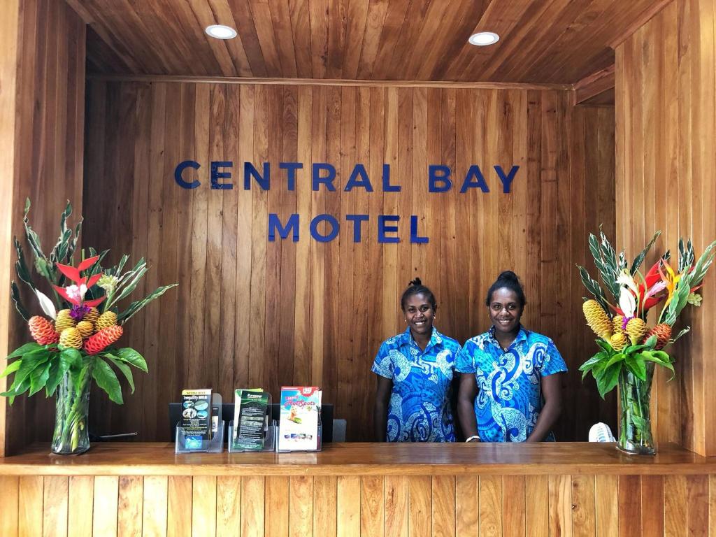 维拉港Central Bay Motel的两个女人站在中央海湾汽车旅馆的柜台后面
