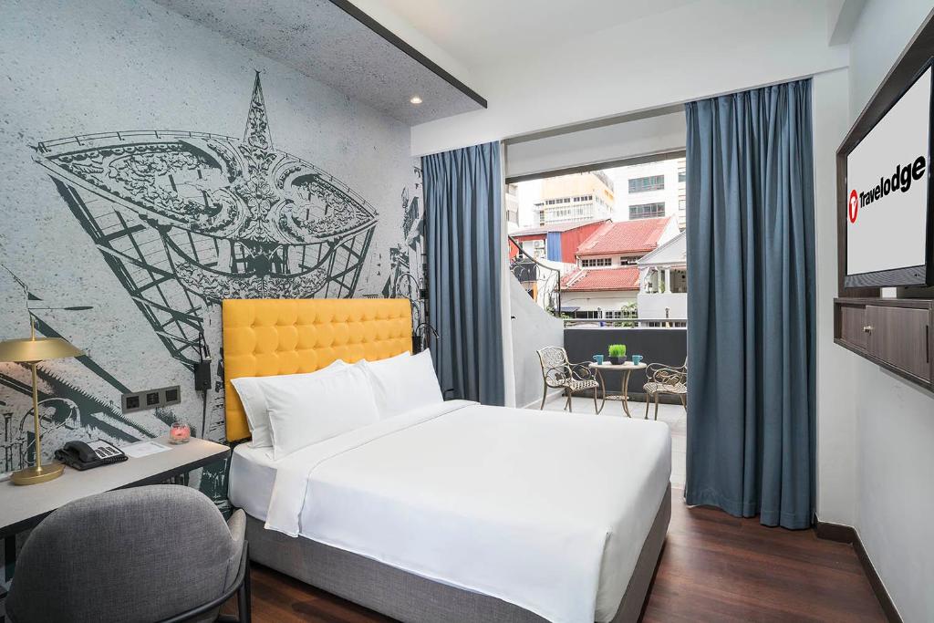 吉隆坡Travelodge Chinatown Kuala Lumpur的配有一张床、一张书桌和一扇窗户的酒店客房