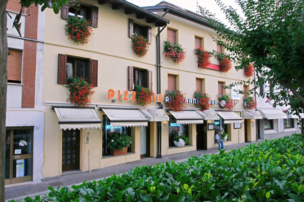 拉蒂萨纳Hotel Ristorante Cigno的一座在阳台上和街道上种满鲜花的建筑