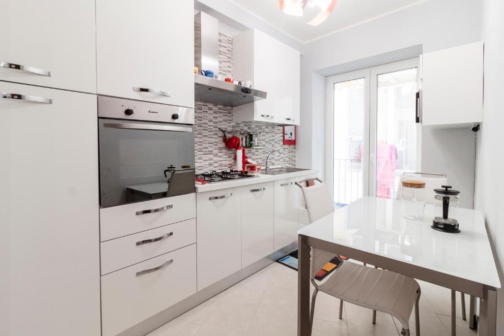 波佐利Casa Gabry的白色的厨房配有白色的橱柜和桌子