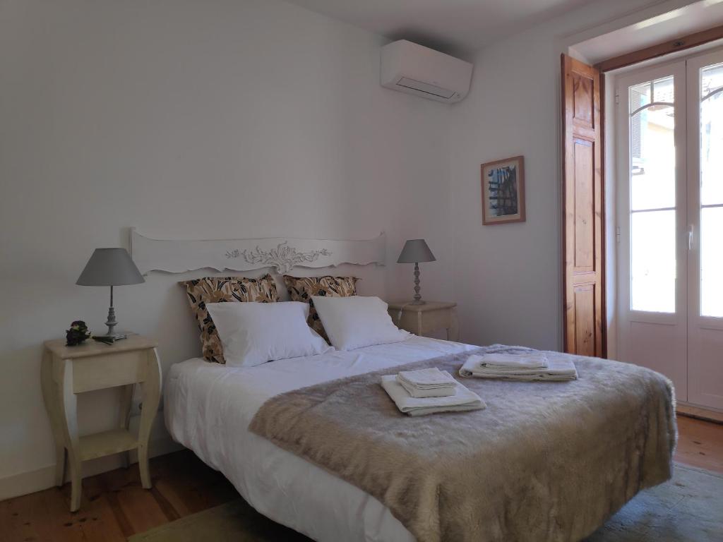 里斯本Casa do Passadiço的一间卧室配有一张大床和两条毛巾